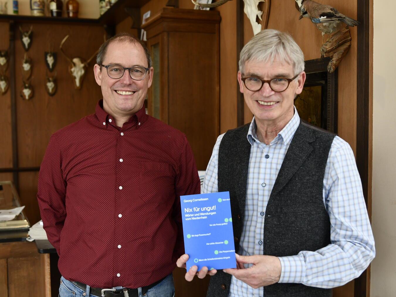 Damian van Melis (l.), Verlagsleiter des Greven-Verlag, lobt Dr. Georg Cornelissen als „Bestseller-Autor des Verlages“. Foto: NMK