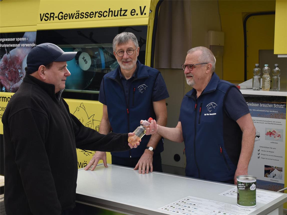 Heinz-Theo van Wickeren und Harald Gülzow nehmen eine Wasserprobe entgegen. Foto: Ruben Witsch